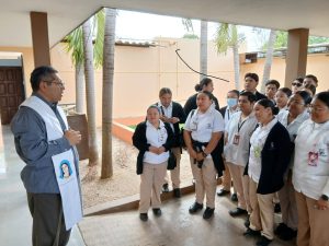Padre Gilberto Pérez dando la bendición a los jóvenes de enfermería